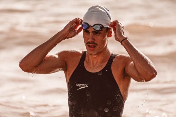 Triathlon swimmer wearing open-water swim goggles during race training