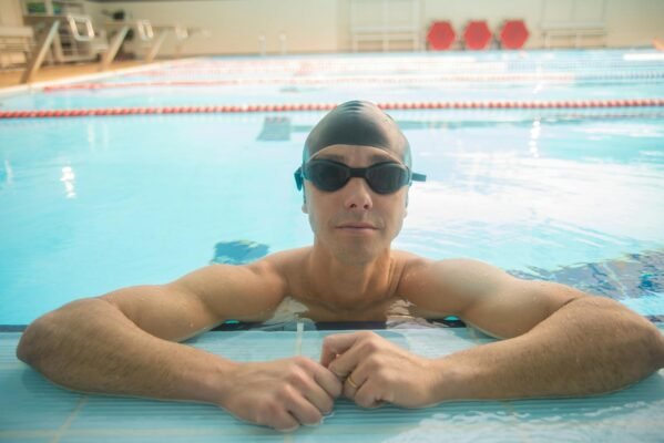 Male swimmer wearing goggles during pool training