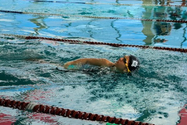 Swimmer adjusting goggles before entering a pool