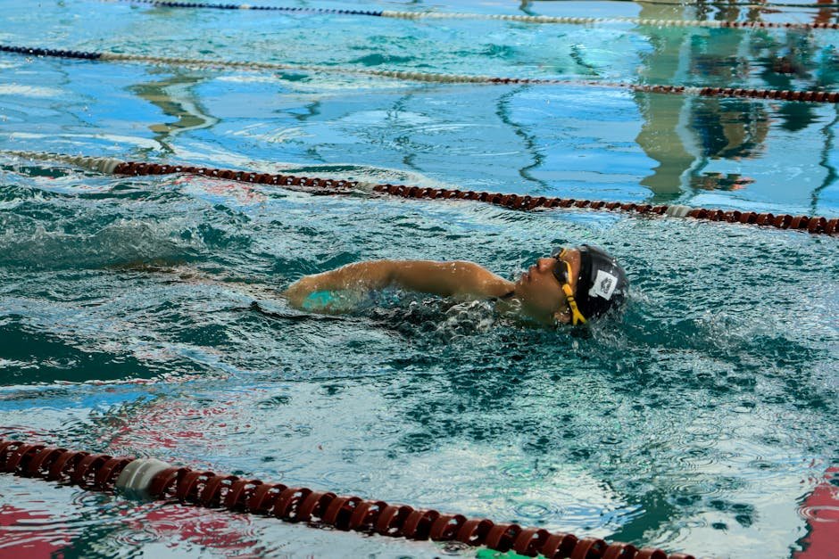 Swimmer adjusting goggles before entering a pool