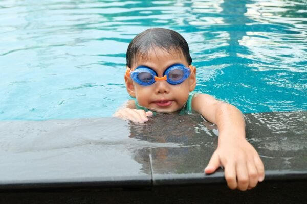 Child wearing swim goggles during a pool lesson