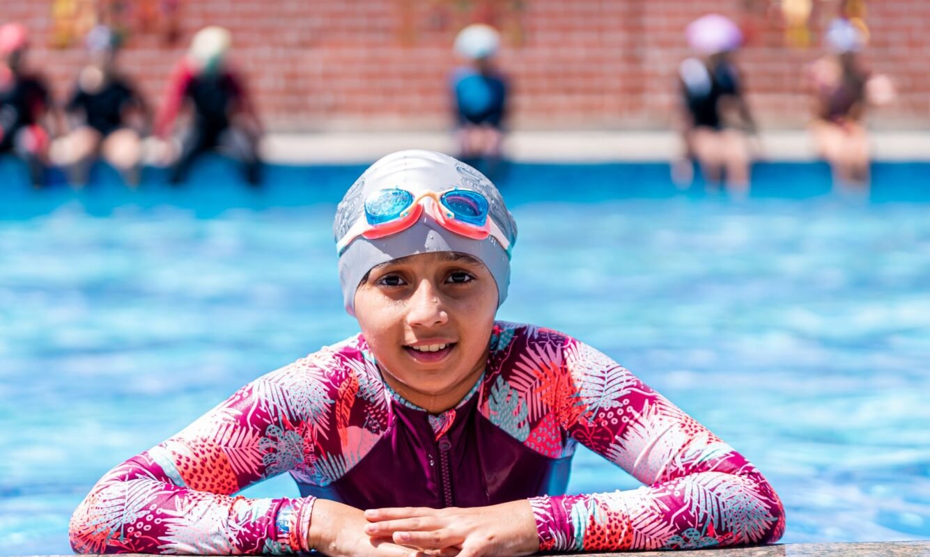 Child wearing swimming goggles during a pool lesson