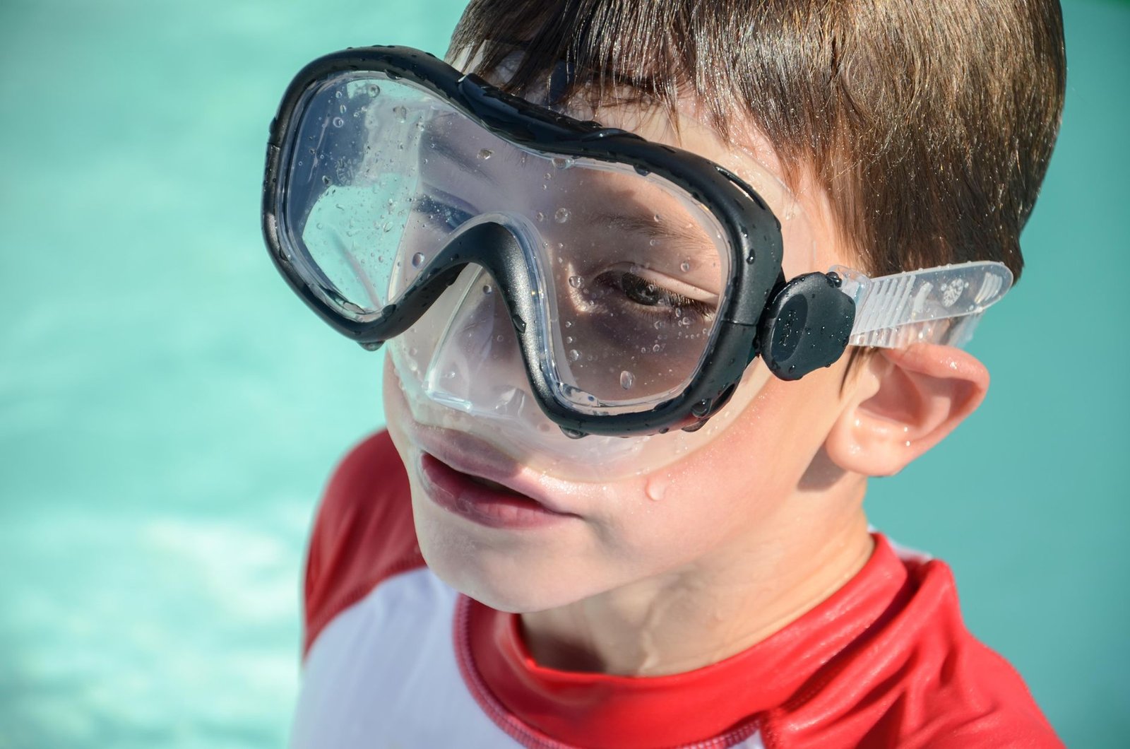 Child wearing swim goggles during a pool lesson