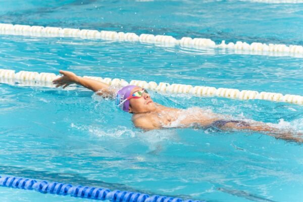 Swimmer wearing mirrored goggles in bright pool light