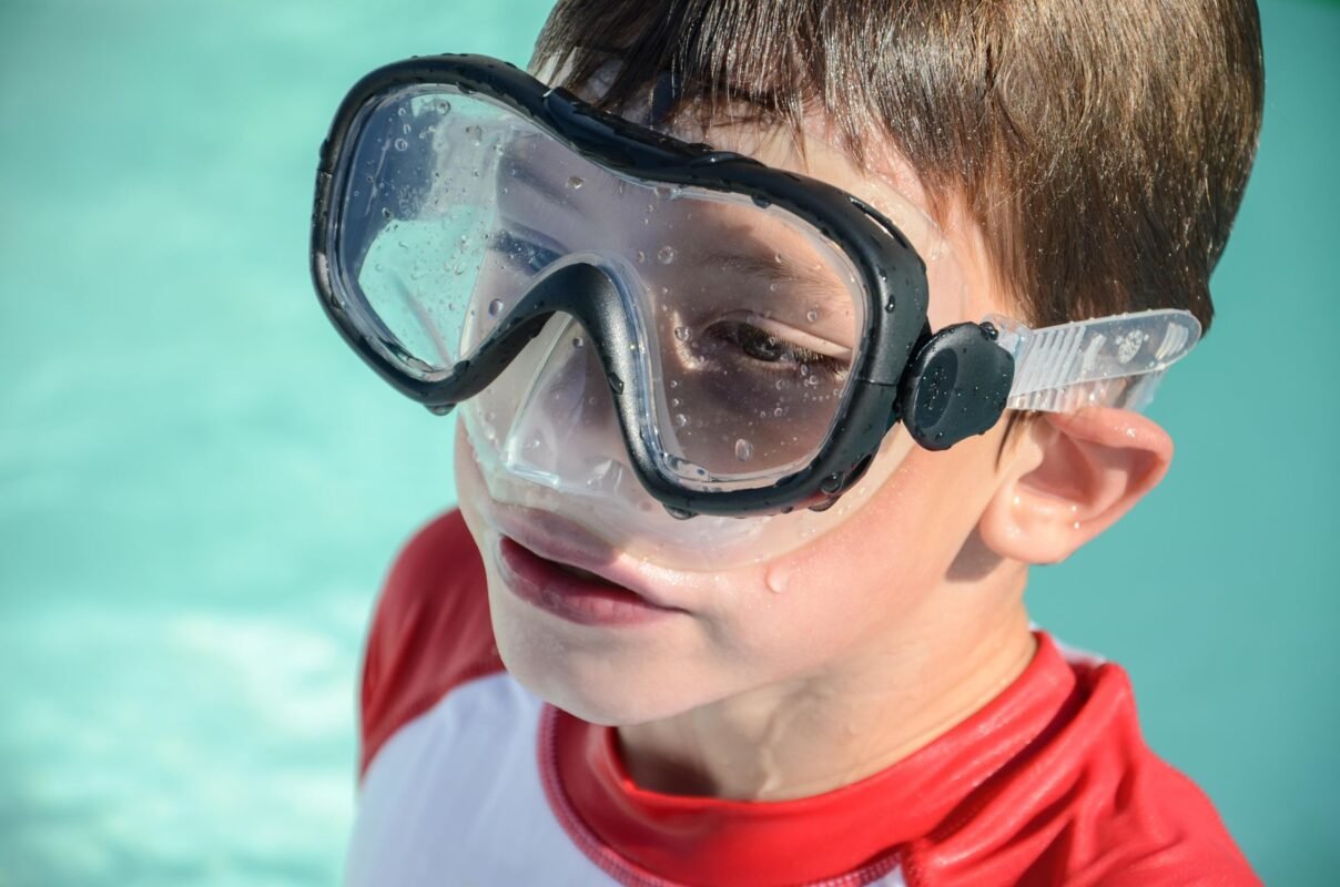 Child wearing swim goggles during a swimming lesson